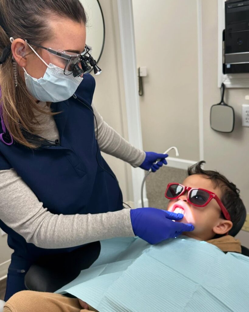 Cornerstone Dental Arts hygienist treating a young pediatric patient wearing protective glasses in Knoxville, TN