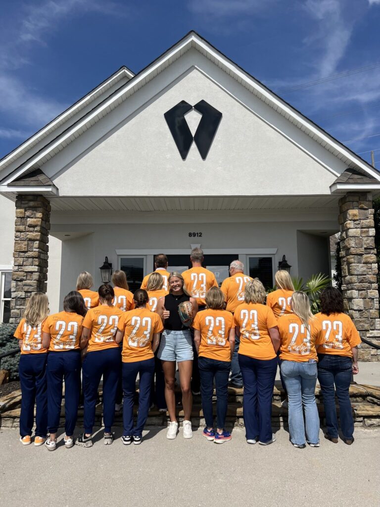 Cornerstone Dental Arts full dental team in matching Tennessee orange shirts in front of the Knoxville office