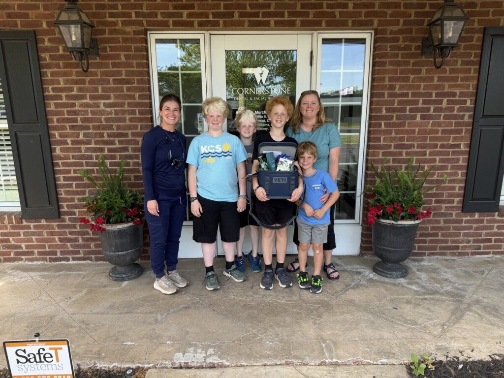 Group of children with Cornerstone Dental Arts team members in front of the Knoxville TN office