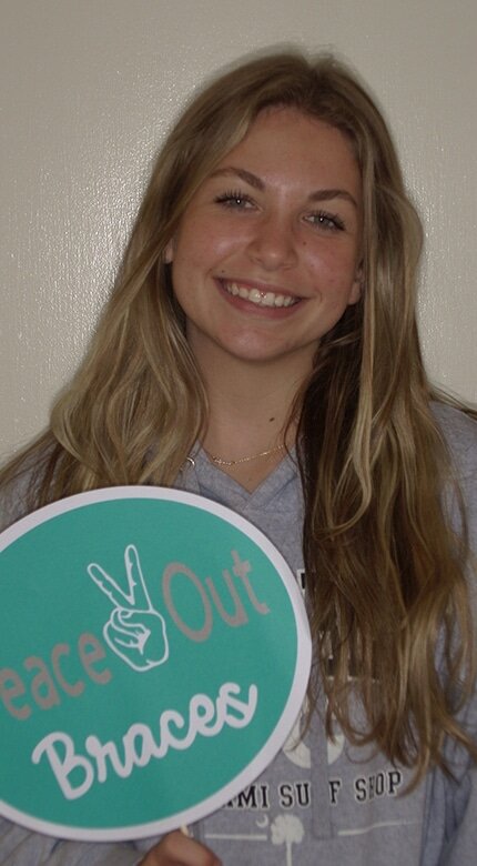 Teen patient with 'Peace Out Braces' sign at Cornerstone Dental Arts, Knoxville, TN