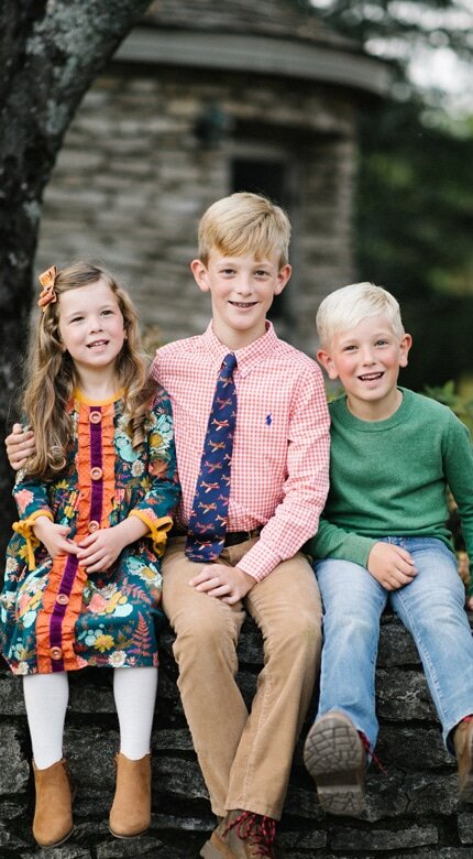 Three siblings smiling outdoors in autumn clothing — Cornerstone Dental Arts smile gallery Knoxville TN