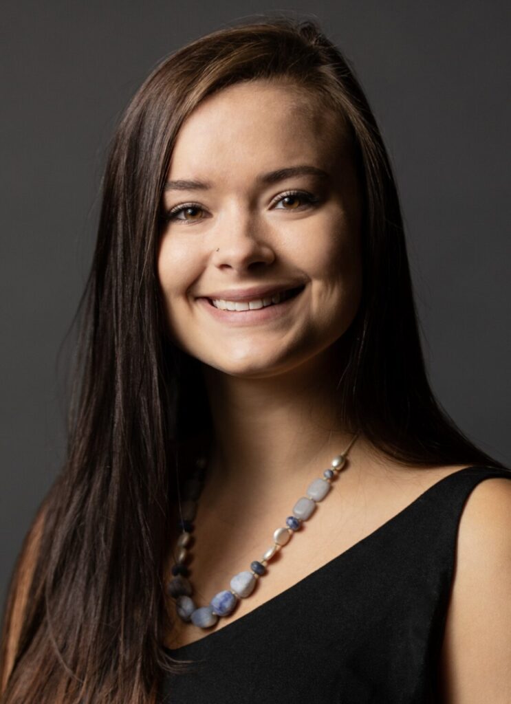 Young woman with long brown hair and beaded necklace smiling in a studio portrait — Cornerstone Dental Arts smile gallery Knoxville TN