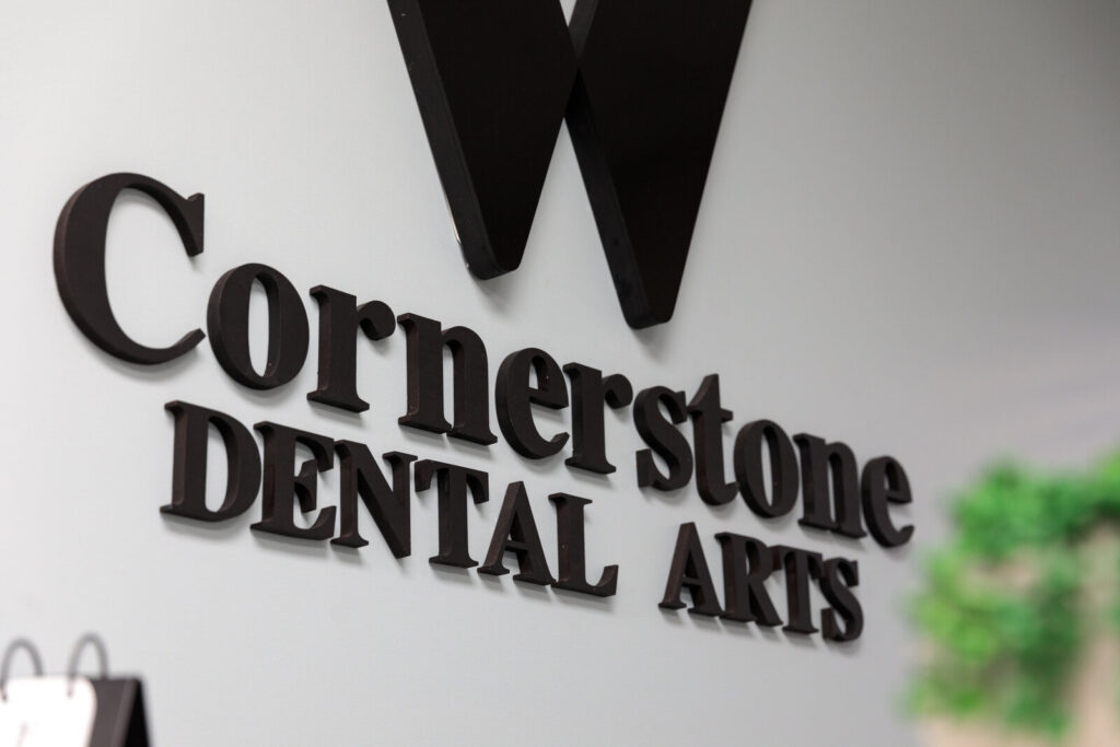 Cornerstone Dental Arts black lettered wall signage with W logo inside the Knoxville, TN office.