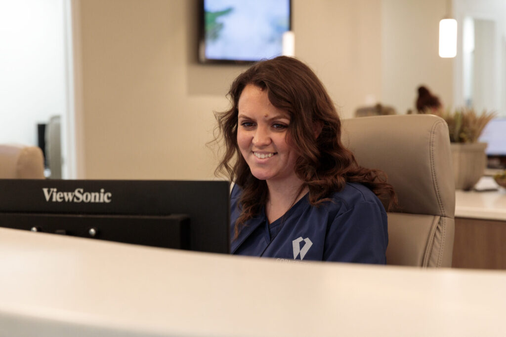 A smiling front desk team member welcoming patients at Cornerstone Dental Arts in Knoxville, TN